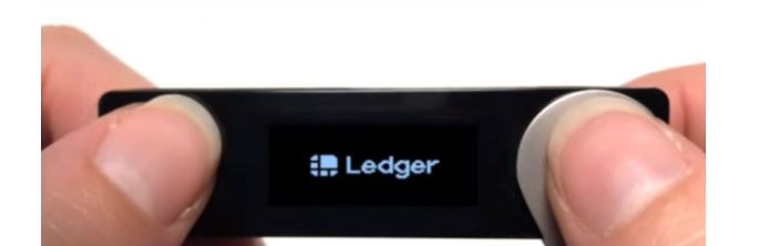 Nhấn giữ nút bên cạnh cổng USD đến khi thấy đèn báo logo Ledger hiện sáng